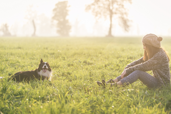 A girl enjoying time with her dog on the lawn contemplating the importance of self-love