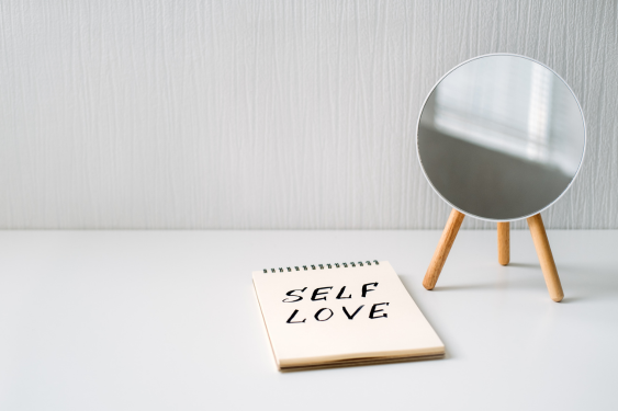 Next to the makeup mirror is a notebook of SELF LOVE