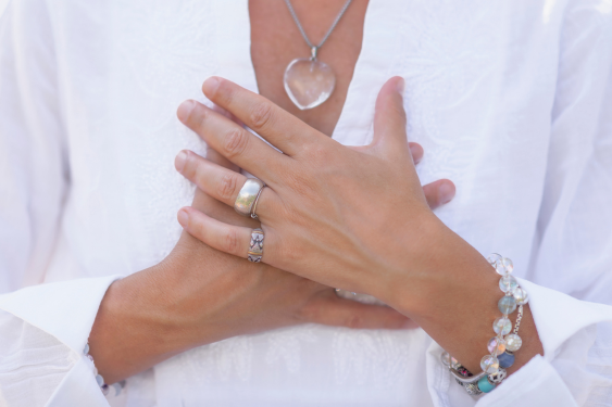 A woman who knows how to love herself puts her hand on her heart