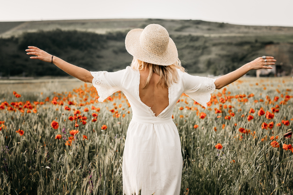 A girl in a dress walks among orange flowers