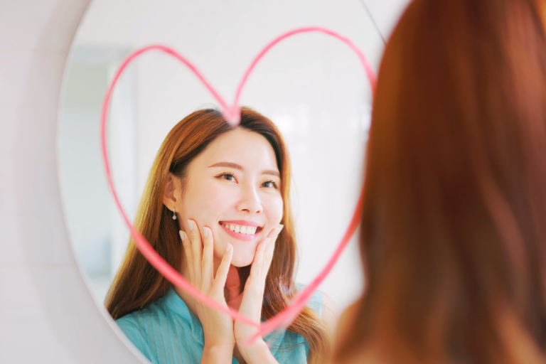 Young woman befriending herself in the mirror