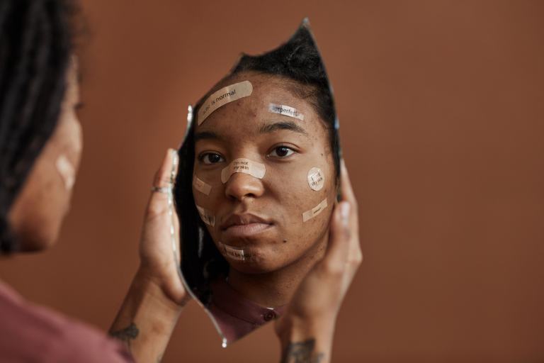 A woman looks at herself in the mirror and tries to heal herself from the pain of family trauma.